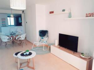 a living room with a flat screen tv and a table at Spacious luxe apartment on Mar Menor Golf Resort with Padel, Fitness, Wellness facilities in Torre-Pacheco