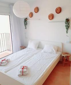 a bedroom with a white bed with two bags on it at Spacious luxe apartment on Mar Menor Golf Resort with Padel, Fitness, Wellness facilities in Torre-Pacheco