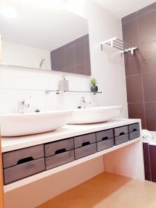 a bathroom with two sinks and a mirror at Spacious luxe apartment on Mar Menor Golf Resort with Padel, Fitness, Wellness facilities in Torre-Pacheco