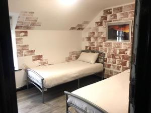 two beds in a room with a brick wall at Finn McCools Giants Causeway Hostel in Bushmills