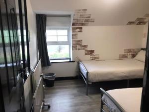 a small room with two beds and a window at Finn McCools Giants Causeway Hostel in Bushmills