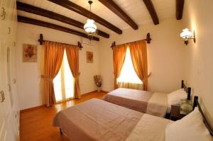 a bedroom with two beds and two windows at Villa Leo Junior in Áno Korakiána