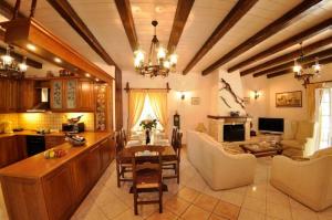 a kitchen and living room with a table and chairs at Villa Leo Junior in Áno Korakiána