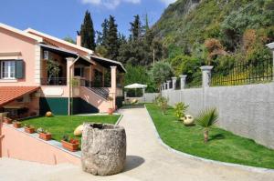 a yard with a house and a fence at Villa Leo Junior in Áno Korakiána
