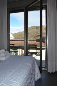a bedroom with a bed and a view of a balcony at Apartamentos Spa Cueto in Cangas de Onís