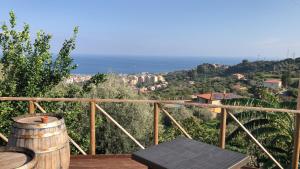 a wooden balcony with a table and a view of the ocean at mammaCristina in Patti