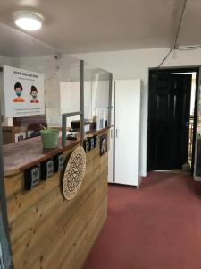 Finn McCools Giants Causeway Hostel في بوشميلس: مطبخ مع كونتر خشبي وباب اسود