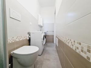 a small bathroom with a toilet and a sink at Finn House in Torre Lapillo
