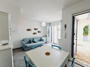 a living room with a table and a blue couch at Finn House in Torre Lapillo +17 photos