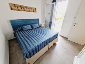a bedroom with a bed with a blue comforter at Finn House in Torre Lapillo