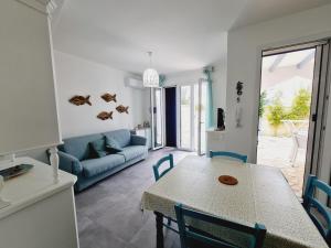 a living room with a table and a blue couch at Finn House in Torre Lapillo