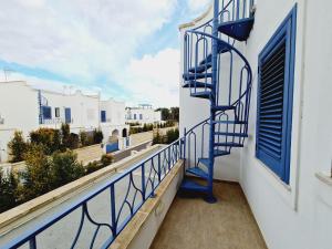 una escalera de caracol azul en un balcón con vistas en Finn House, en Torre Lapillo