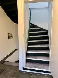 eine Treppe mit grünem Handlauf in einem Gebäude in der Unterkunft Dachgeschosswohnung mit Seeblick in Ahrensbök