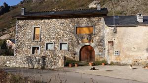 a stone building with a door and two dogs in front at Casa Rural Las Verdes l y II in Torre de Babia