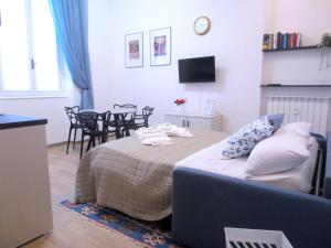 een slaapkamer met een bed en een tafel en stoelen bij La Câza a Zêna in Genua