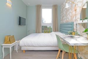 1 dormitorio con cama, escritorio y ventana en The Green Room - Duke Housing en Créteil