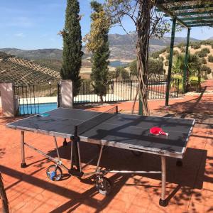a ping pong table sitting on top of a patio at Cortijo Rocas Altas in Iznájar +20 photos