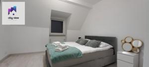una camera da letto con un letto con asciugamani sopra di CITY VIEW Kanonierska - przy parku blisko centrum a Świdnica