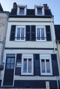 a white building with black shutters on it at L'ESTRAN in Saint-Valery-sur-Somme