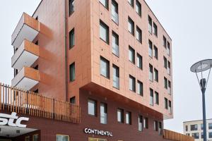 um edifício alto e vermelho com um sinal. em Continental Apartment Hotel Knivsta em Knivsta
