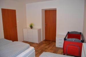 Apartmán Pod Říčkami في روكتنيتسه في أورليتسكي هوراش: غرفة نوم بسرير وحقيبة حمراء