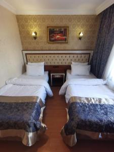 a hotel room with two beds and two nightstands at Big Apple Hotel in Istanbul