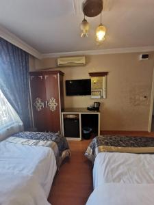 Habitación de hotel con 2 camas y TV de pantalla plana. en Big Apple Hotel, en Estambul