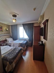 イスタンブールにあるBig Apple Hotelのベッド2台と窓が備わるホテルルームです。