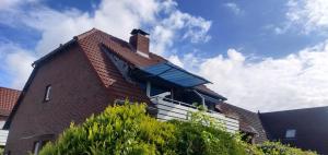ein rotes Backsteinhaus mit blauem Dach in der Unterkunft Ferienwohnung Likedeelers in Norddeich