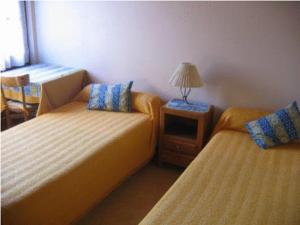 a room with two beds and a table with a lamp at Chalet Bois Vallons Chambres d'Hôtes in Morzine