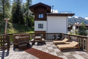 a deck with two chairs and a grill on a house at Rosa Chalet Rosa Khutor in Estosadok