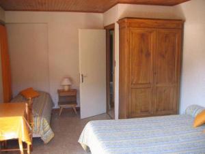 モルジヌにあるChalet Bois Vallons Chambres d'Hôtesのベッドルーム1室(ベッド1台付)、木製キャビネットが備わります。