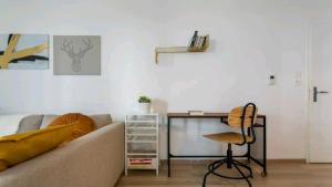 a living room with a couch and a desk at Luxury Apartment near Paris la Défense with secured Parking in Bois-Colombes