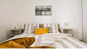 a bedroom with a bed with a yellow blanket on it at Luxury Apartment near Paris la Défense with secured Parking in Bois-Colombes