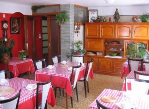 una sala da pranzo con tavoli e sedie rossi e bianchi di Chalet Bois Vallons Chambres d'Hôtes a Morzine