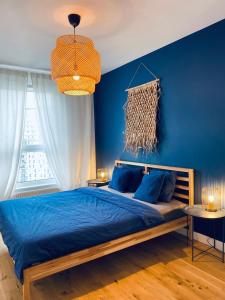 Un dormitorio azul con una cama y una pared azul. en Apartament z Widokiem na Morze, en Gdansk