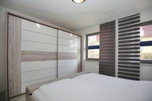 ein Schlafzimmer mit einem weißen Bett und einem Fenster in der Unterkunft Hanse-Haus Wohnung 04 in Boltenhagen