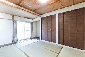 una stanza vuota con porte in legno e finestra di Keiko"s Home 宮浦一日一組限定海の絶景オーシャンビューのラグジュアリー別荘2000m2BBQ可海釣公園 a Fukuoka
