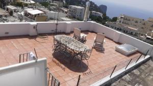 um pátio com uma mesa e cadeiras no telhado em Regina di Capri - Sopramonte - em Capri