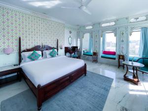 a bedroom with a large bed and some windows at Amar Kothi in Udaipur