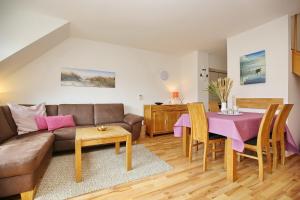 - un salon avec un canapé et une table dans l'établissement Feriendorf Papillon Wohnung 08-7, à Boltenhagen