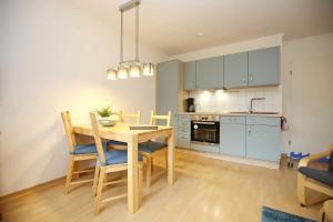 een keuken en eetkamer met een tafel en stoelen bij Urlauberdorf Haus 22c in Boltenhagen