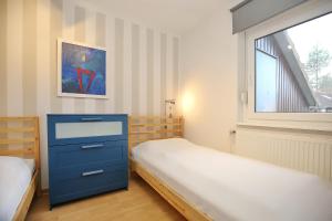 een slaapkamer met 2 bedden en een blauwe dressoir bij Urlauberdorf Haus 22c in Boltenhagen