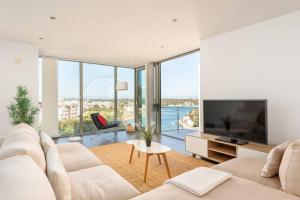 a living room with a white couch and a tv at Blue Port in Mahón