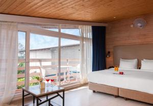 a bedroom with a large bed and a large window at Living Room Beach Resort in Morjim