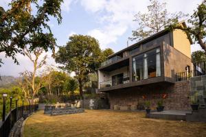 a house with a large window on the side of it at SaffronStays Elysian, Dehradun - best mountain views from this party - All clear roads in Dehradun