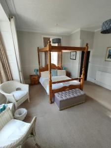 1 dormitorio con cama con dosel y silla en Valentine Guest House, en Weymouth