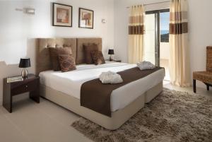 a bedroom with a large white bed and a window at Belmar Spa & Beach Resort in Lagos