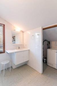 Baño blanco con lavabo y espejo en Gîte de la Charrière, en Montboillon