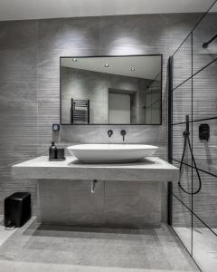 a bathroom with a sink and a large mirror at J&A Luxury Residence in Athens